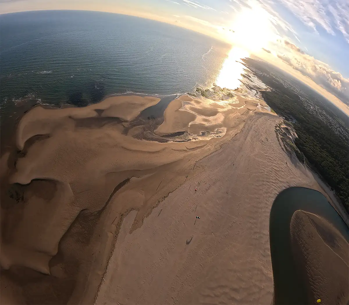 Vue aérienne époustouflante de la plage du Veillon depuis un parachute tandem : estuaire sinueux, dunes dorées et océan turquoise