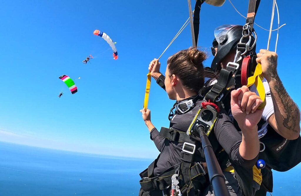 Miniature vidéo Voile contact au-dessus de la baie des Sables. Le tandem au premier plan observe deux tandems volant ensemble. Nous adorons quand vous et vos proches vivez le saut au plus près l